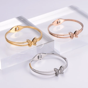 Detailed view of butterfly bangles in gold, rose gold and silver with zircon accents