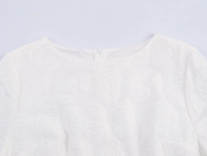 Close-up of white round neck dress with floral texture and back invisible zipper