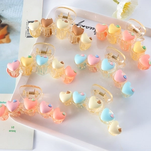 Macro shot of assorted heart-shaped matte hair claws in various macaron pastel colors