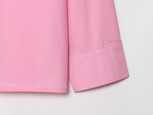 Close-up of pink long sleeve shirt showing premium cotton fabric and stitching details