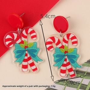 Detail of candy cane Christmas earrings with red and white stripes and blue bows