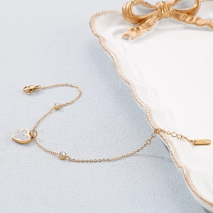 Close-up of gold titanium steel heart bracelet with sparkling rhinestones and lobster clasp