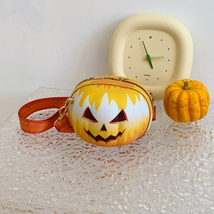 Macro detail of pumpkin shaped crossbody bag with smiling face and patterned strap
