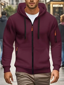 Detail of burgundy zip-up hoodie with black drawstring and orange zipper accents