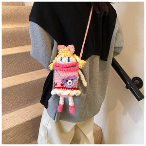 Detail view of pink crochet crossbody bag with yellow hair character and purple bear doll