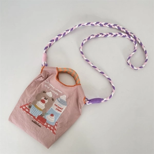Détail du mini sac rose en tissu Oxford avec broderie ours et bandoulière tissée