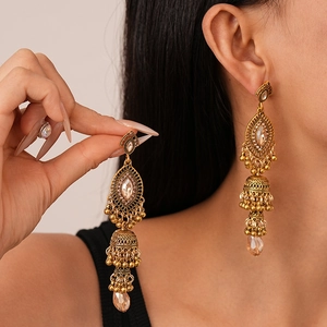 Vintage Jhumka drop earrings with crystals and tassels shown on a model's ear
