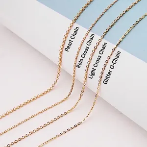 Detail of four textured 18K gold plated silver chains including pearl and O-cross styles