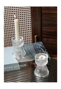 Detailed view of striped glass candle holder with elegant ribbed texture on a wooden desk