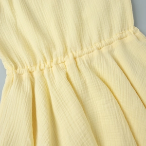 Detailed macro view of the yellow crinkled cotton fabric and elastic waist stitching