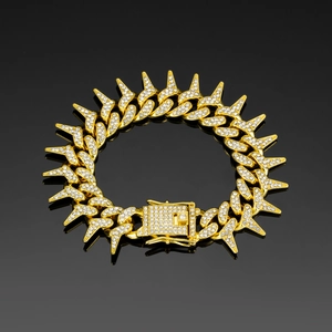 Detailed macro shot of 20mm gold-plated spiked Cuban chain with iced out rhinestones