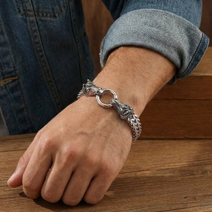 Detailed view of men's stainless steel bracelet with dual horse head buckle on wrist