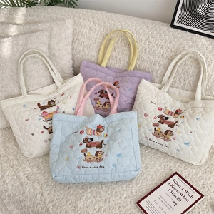 Close-up of heart-shaped quilted cotton bag with cute dog embroidery and sweet text