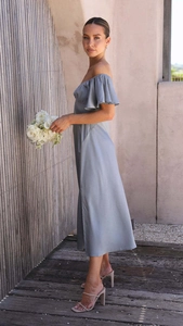 Détail de la robe en satin bleu clair avec volants dénudés et texture soyeuse