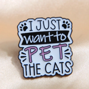 Enamel cat pin badge with I Just Want To Pet The Cats text on luxury silk background