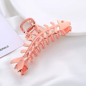 Détail de la pince à cheveux en forme d'arête de poisson avec finition métal rose doré