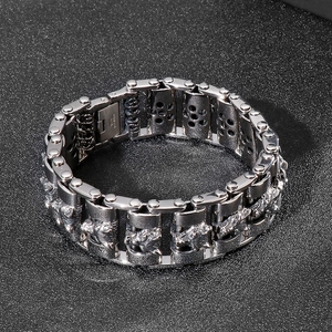 Close-up of a silver stainless steel lion head relief on a heavy biker chain bracelet