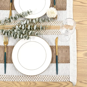 Boho woven table runner with cream brown stripes and tassels on a wooden dining table