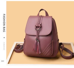 Dettaglio dello zaino in morbida ecopelle viola con manico intrecciato e decorazione nappa
