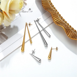 Detailed view of long tapered gold and silver teardrop earrings on a clean white surface