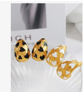 Dettaglio di orecchini a goccia con smalto a cuore bianco e nero in stile lusso