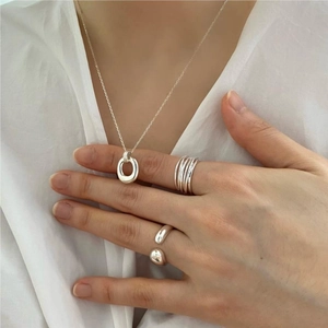 Minimalist 925 sterling silver jewelry set featuring a necklace and rings on a model