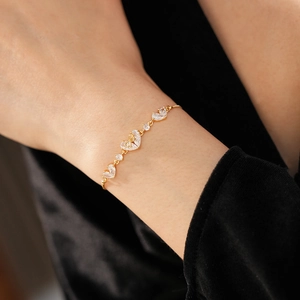 Detailed shot of 18K gold plated heart bracelet with sparkling zircon stones on a model