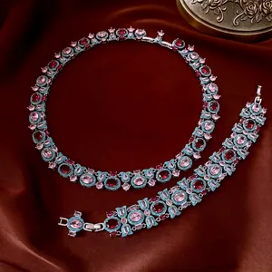 Set di gioielli vintage con pietre preziose ovali su sfondo di seta rossa lussuosa