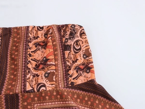 Détail des motifs floraux ethniques bohèmes sur le tissu d'une robe longue bustier