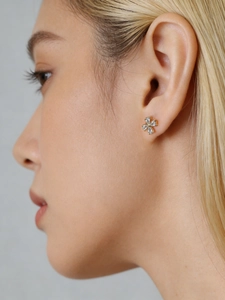 Close-up of minimalist S925 sterling silver flower stud earrings worn by a model