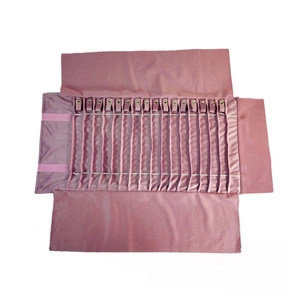 Pink velvet jewelry roll showing 18 slots with snap buttons for necklace storage
