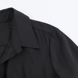 Close-up of black shirt dress collar with sharp lapel and fine stitching details