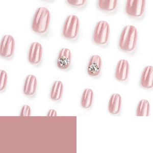 Pink cat-eye press-on nails with rhinestone accents in a short round shape