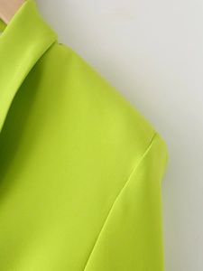Détail du blazer vert citron montrant le revers et les coutures de l'épaule soignées
