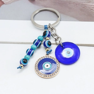 Detail of blue evil eye keychain with turquoise glass beads and rhinestone metal charm