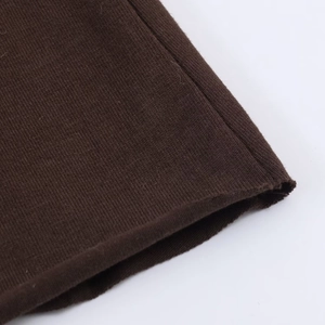 Close-up of dark brown knit dress showing ribbed texture and rolled hem stitching detail