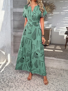 Detail of V-neck printed green jumpsuit with waist belt and wide leg design