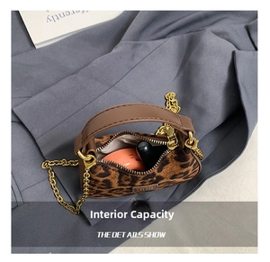 Détail de l'espace intérieur du mini sac léopard avec chaîne dorée et cosmétiques