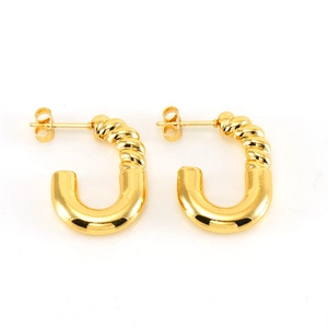 Gros plan de boucles d'oreilles C dorées avec motif torsadé et fini poli brillant