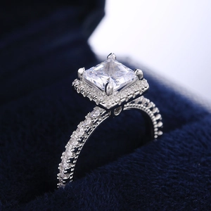 Macro shot of square princess cut diamond ring in a navy blue velvet jewelry box