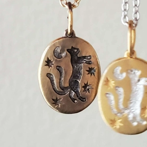 Détail du pendentif tarot ovale avec chat noir et lune en relief et plaquage en or 18K