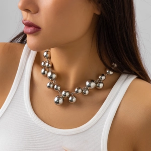 Detail of punk silver metal ball necklace on model neck highlighting sleek industrial style