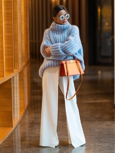 Women's light blue turtleneck knit sweater with loose sleeves and white wide-leg trousers