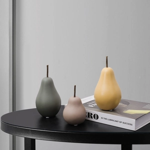 Décoration de poire en céramique minimaliste aux couleurs Morandi sur table noire