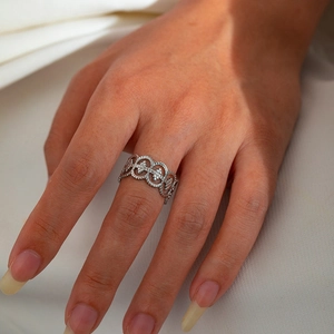 Macro detail of silver titanium steel hollow filigree ring worn on a finger