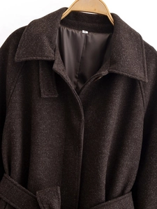 Detail of dark brown wool blend coat lapel and shoulder structure on a wooden hanger