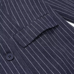 Detail eines dunkelblauen Nadelstreifen-Wollblazers mit Taschenklappe und dunklem Knopf