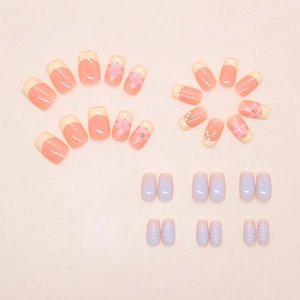 Detail of French blue ombre press-on nails with 3D floral accents and pearls