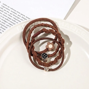Detailed view of high-elasticity brown hair ties with metal heart and floral charms