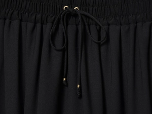 Close-up of elastic waistband with black drawstring and gold metal aglets on dress